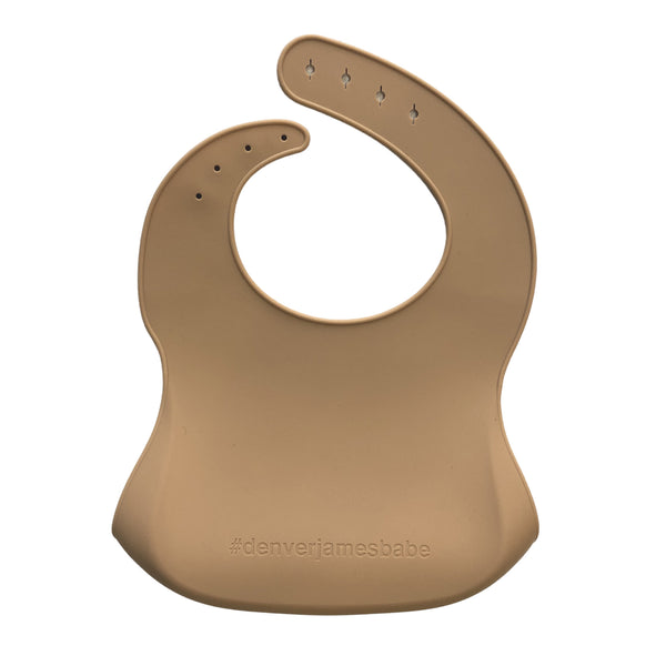 back view of a beige silicone bib with '#denverjamesbabe' branding on a white background