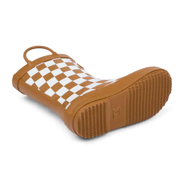Detail image of chocolate and white checkered colored children's rain boot focusing on the sole with texture and size stamped into the bottom on a white background.