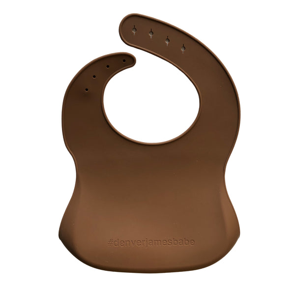 Back view of a dark brown silicone bib on a white background with '#denverjamesbabe' text.