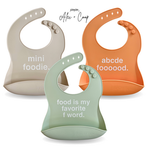 Alec Treffs Silicone bib multi pack of silicone bibs on white background with official signature. 