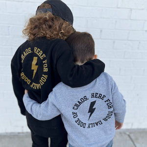 2 boys hugging while wearing Chaos designed sweatshirts in the street. 