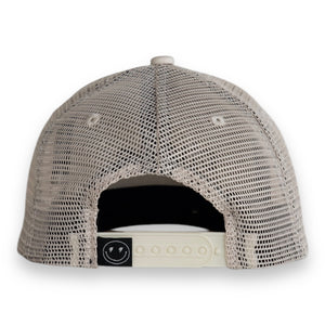Toddler hat with snap back and smiley face tag in black on white background. 