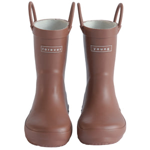 Front view of a pair of chocolate colored rain boots for children. Showing pull handles for easy slip on and tags that say "Forever Young" on the front. 
