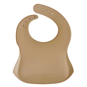 Back view of a beige Silicone bib on a white background with '#denverjamesbabe' text.