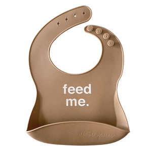 Front View of a brown silicone food catcher bib with 'feed me.' text on a white background.