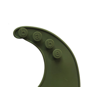 detail image of a bright green silicone bib on a white background with 'babe' buttons. 