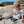 Light Brown | Kid sitting on pebble driveway wearing light brown beanie. 
