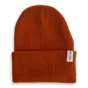 Rust colored kids beanie with 'wild child' label. 