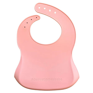 back view of a pink silicone baby bib with '#denverjamesbabe' text on a white background