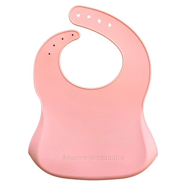 back view of a pink silicone baby bib with '#denverjamesbabe' text on a white background