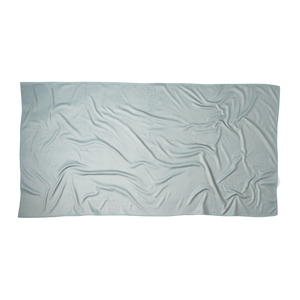 an overhead shot of the back of a green microfiber beach towel showing the texture of the fabric and the rectangular dimensions of the towel. there is nothing printed on the back, it is a solid color.