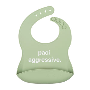Front View of a light green silicone food catcher bib with 'paci aggressive.' text on a white background.