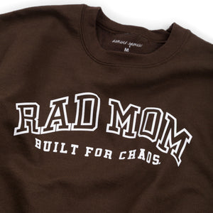 Detail view of a Brown sweatshirt with 'RAD MOM BUILT FOR CHAOS' text on a white background