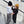 2 boys wearing sweatshirts and beanies standing on stairs high five ing. 