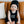 image of baby sitting on couch wearing black beanie and romper that says 'wild child'. 