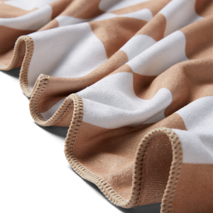 a detailed image of a beige microfiber towel showing the edge stitching as well as the texture of the towel.