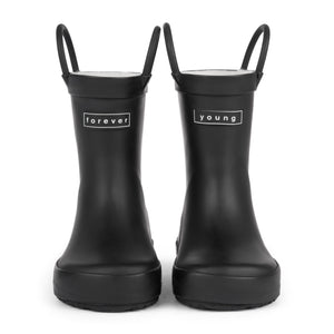 Front view of a pair of black colored rain boots for children. Showing pull handles for easy slip on and tags that say "Forever Young" on the front. 