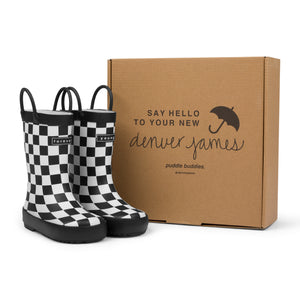 Black and white checkered rain boots with a cardboard box branded with 'Denver James' on a white background. 