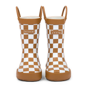 Front view of chocolate and white checkered children's rain boots with 'forever young' branding on a white background.