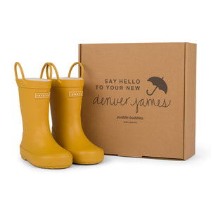 Golden colored rain boots with a cardboard box branded with 'Denver James' on a white background. 