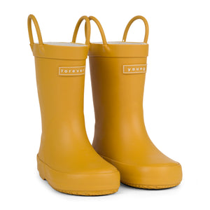 Front 3/4 view of a pair of golden colored rain boots for children. Showing pull handles for easy slip on and tags that say "Forever Young" on the front. 