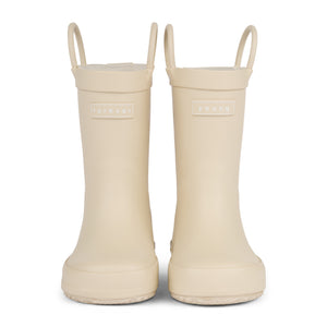 Front view of a pair of sand colored rain boots for children. Showing pull handles for easy slip on and tags that say "Forever Young" on the front. 