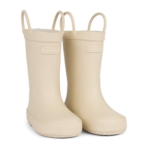 Front 3/4 view of a pair of sand colored rain boots for children. Showing pull handles for easy slip on and tags that say "Forever Young" on the front. 