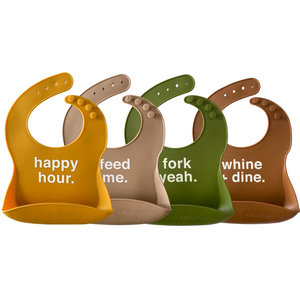 4 multi earth colored baby bibs on a white background with funny sayings on them. 