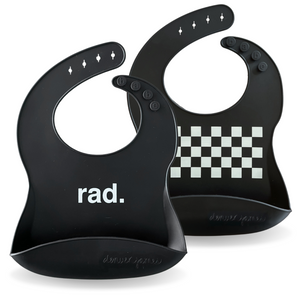 Two black baby bibs with 'rad.' text and checkered pattern on a white background