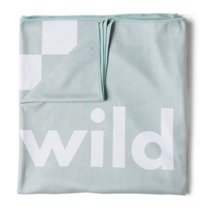 A green microfiber beach towel with the word 'wild' printed in large white letters, folded and displayed on a flat surface.